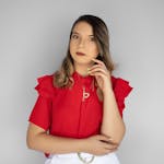 Sophisticated studio portrait of a woman in a bright red blouse against a white backdrop.