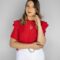 Sophisticated studio portrait of a woman in a bright red blouse against a white backdrop.